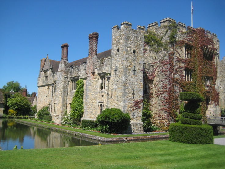 an old castle with ivy growing on it's sides and water in the foreground