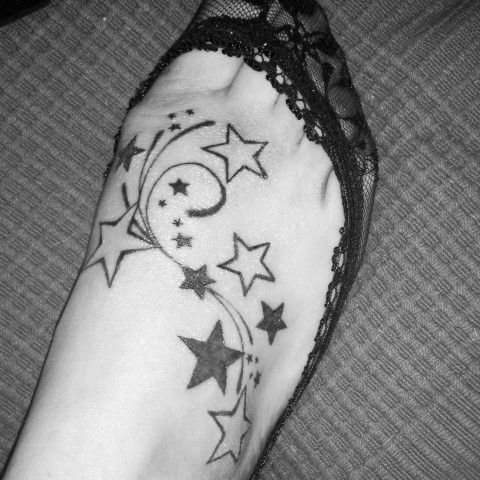 a black and white photo of a person's arm with stars on it,