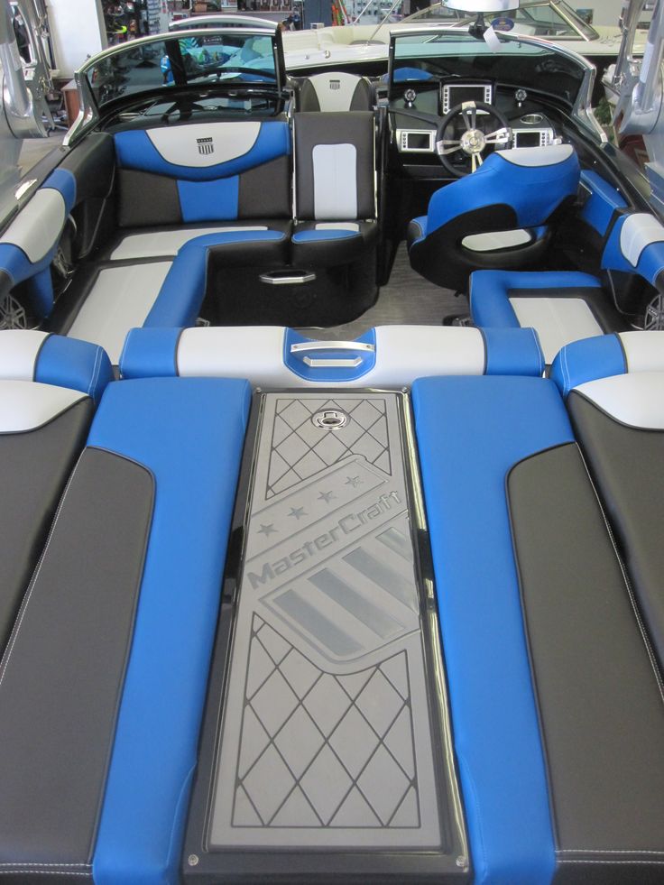 the interior of a blue and white boat with seats on it's back end