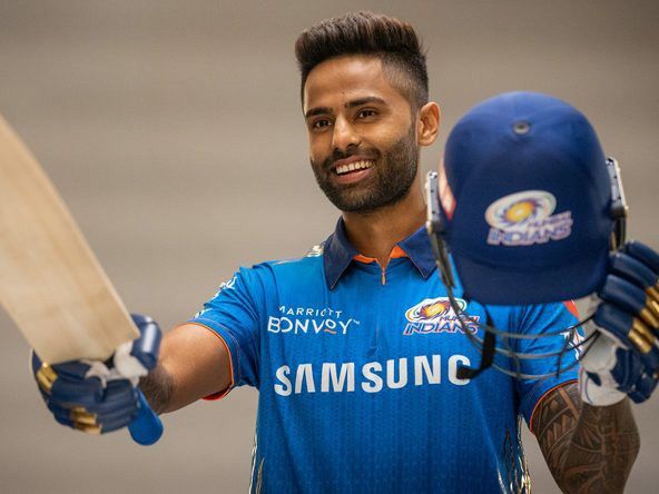 a man holding a cricket bat and helmet