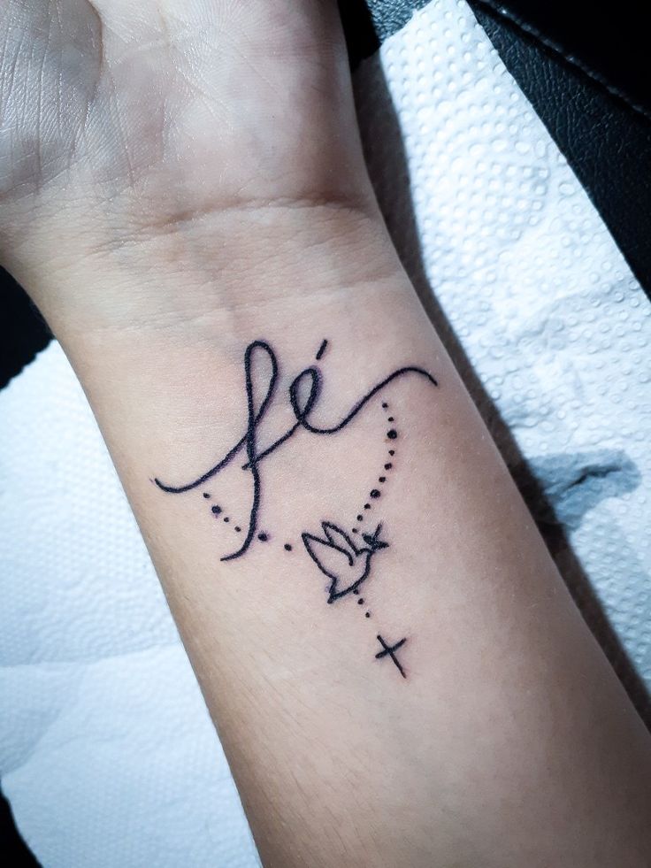 a wrist tattoo with the word love written in cursive writing