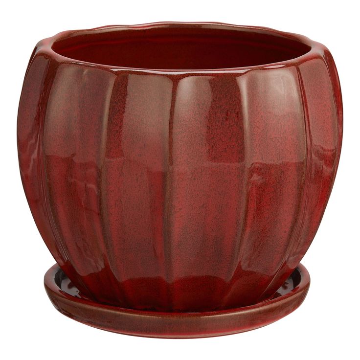 a large red vase sitting on top of a wooden stand