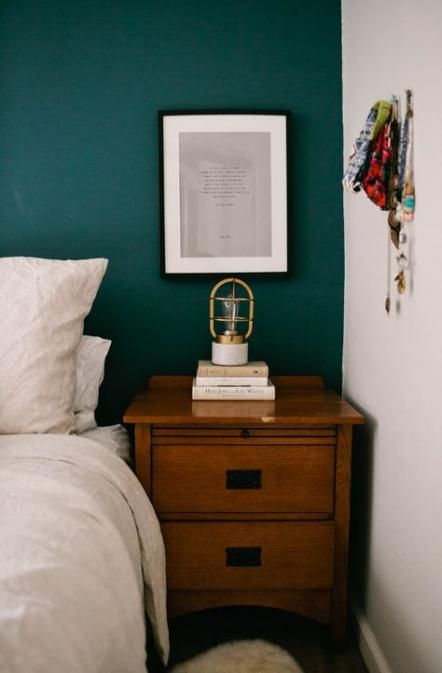 a bedroom with green walls and white bedding, two nightstands on each side