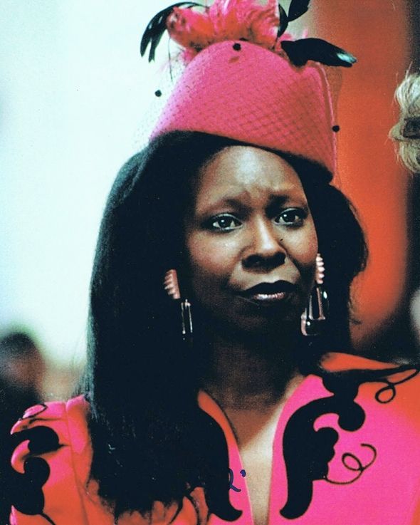 a woman wearing a pink hat and earrings