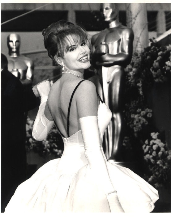 an old black and white photo of a woman in a dress at the oscars