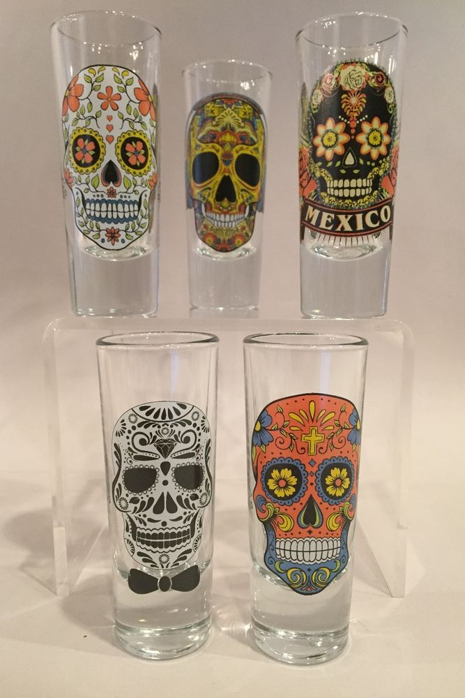 four glasses with different designs on them sitting next to each other in front of a white background