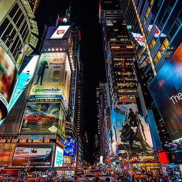 the times square in new york city is lit up at night with many billboards