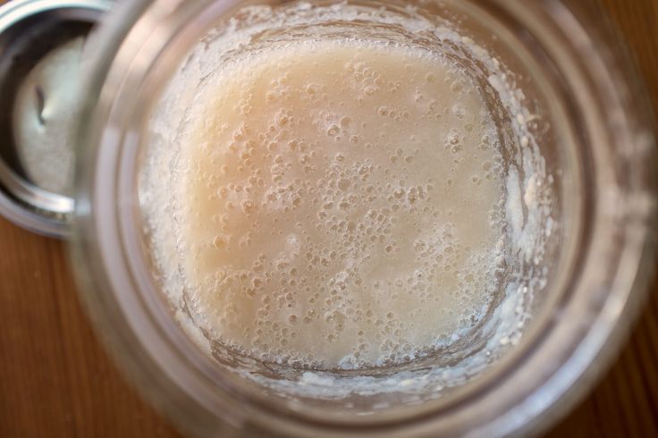 a glass jar filled with liquid on top of a wooden table