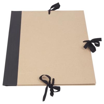 an open notebook with black ribbon tied around it