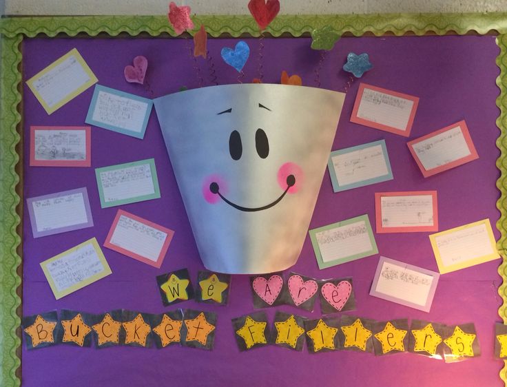 a bulletin board with some writing on it and a paper cup that has a smiley face