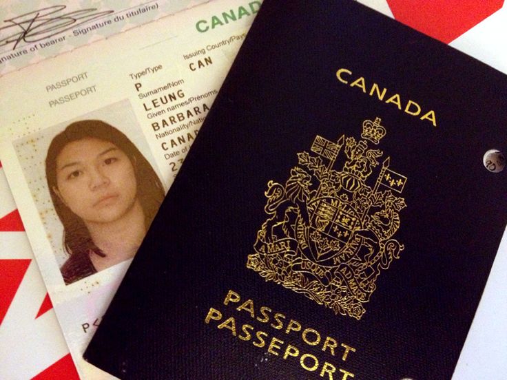 a canadian passport sitting on top of a red and white checkered table