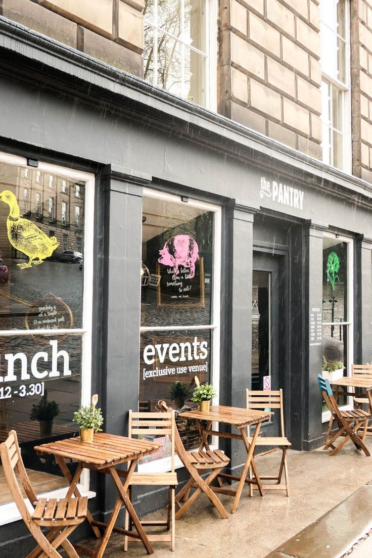 the outside of a restaurant with wooden tables and chairs