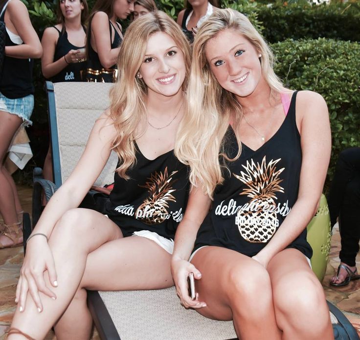 two beautiful young women sitting next to each other on top of a chair at a party