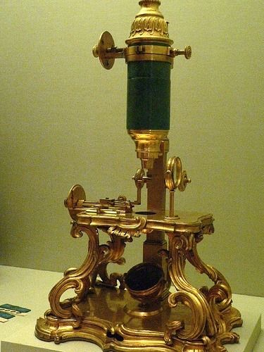 an antique brass microscope on display in a museum