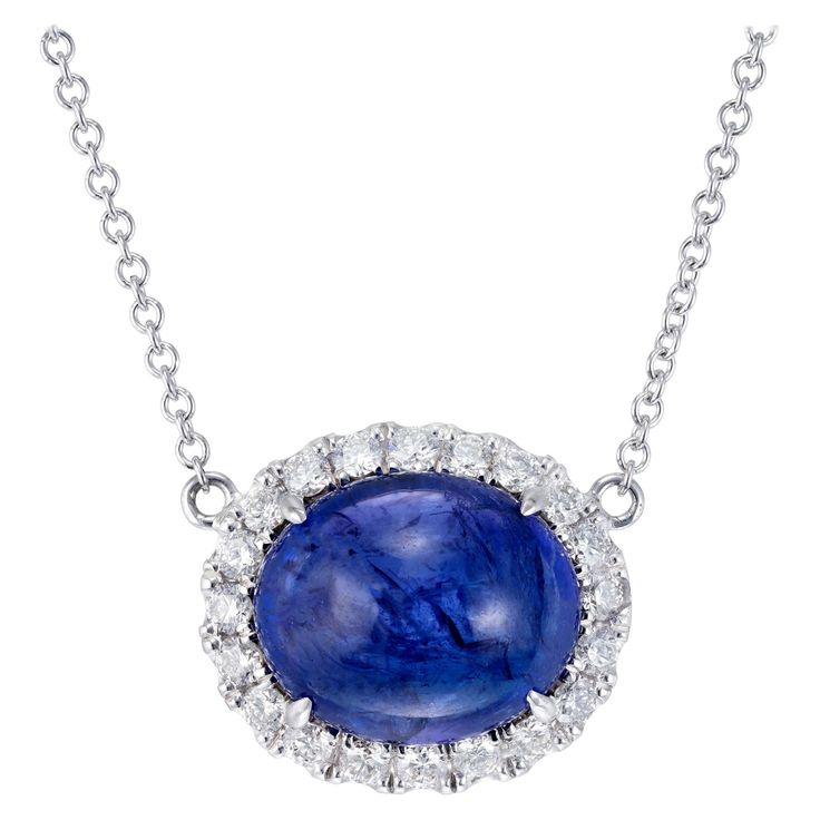 Vivid blue earth mined tanzanite and diamond pendant necklace. 8.00 carat oval cabochon center stone with blue and purple overtones surrounded a brilliant cut diamond halo. 18 inch 18k white gold chain. Created in the Peter Suchy Workshop 1 oval cabochon blue tanzanite, MI approx. 8.00cts 20 round brilliant cut diamonds, F-G VS, approx. .40cts 18k white gold Stamped: 18k 750 5.9 grams Top to bottom: 13.2mm or .5 Inch Width: 15.8mm or 5/8 Inch Depth or thickness: 9.8mm Chain: 18 Inches Total leng Round Pendant Necklace 1stdibs, Diamond Cabochon Pendant Necklace, Luxury Tanzanite Necklace With Brilliant Cut, Formal Round Cabochon Necklaces, Brilliant Cut Sapphire Oval Pendant, Sapphire Jewelry With Brilliant Cut Oval Pendant, Luxury Tanzanite Jewelry With Polished Finish, Oval Cabochon Necklace In Fine Jewelry Style, Oval Diamond Cabochons For Formal Occasions