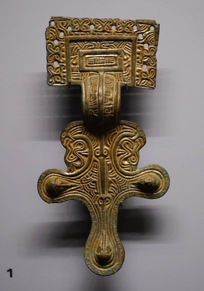 an ornate brass door handle on a white wall