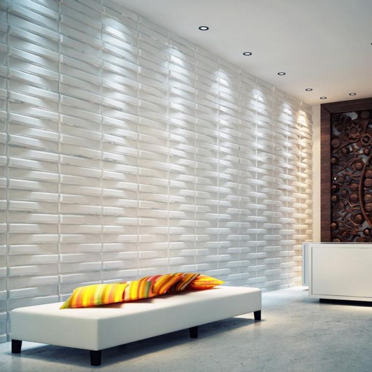 a white couch sitting in front of a wall with decorative tiles on it's sides