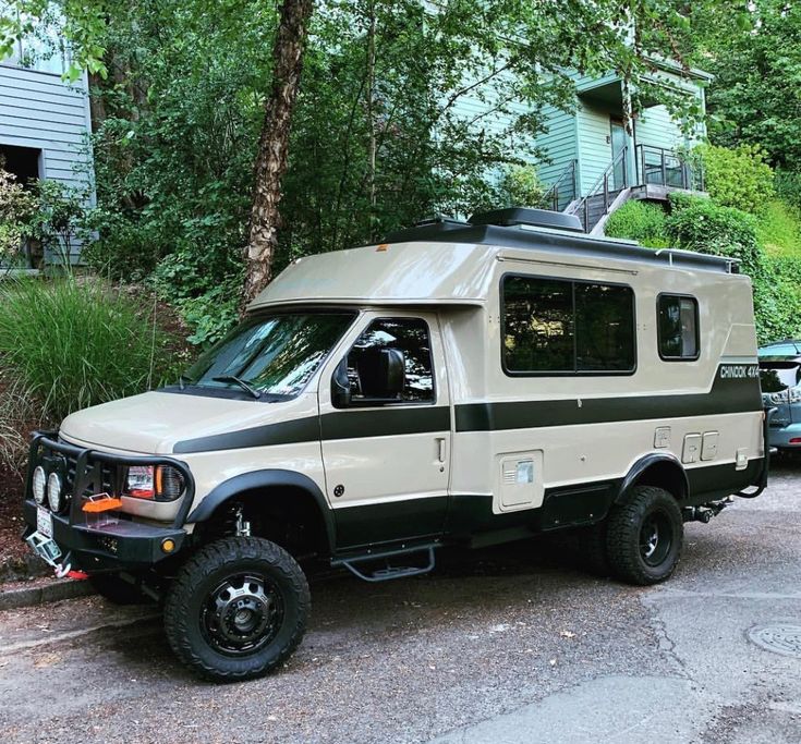 an off - road camper parked in front of a house