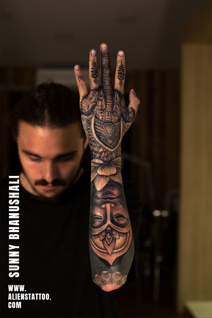 a man with tattoos on his arm and hand