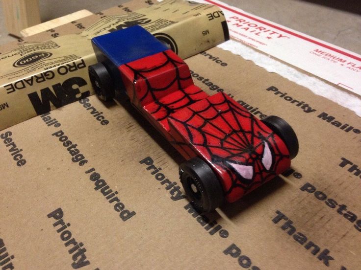 a toy car made to look like a spider man is sitting on top of cardboard boxes