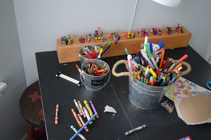 two buckets filled with crayons sitting on top of a table