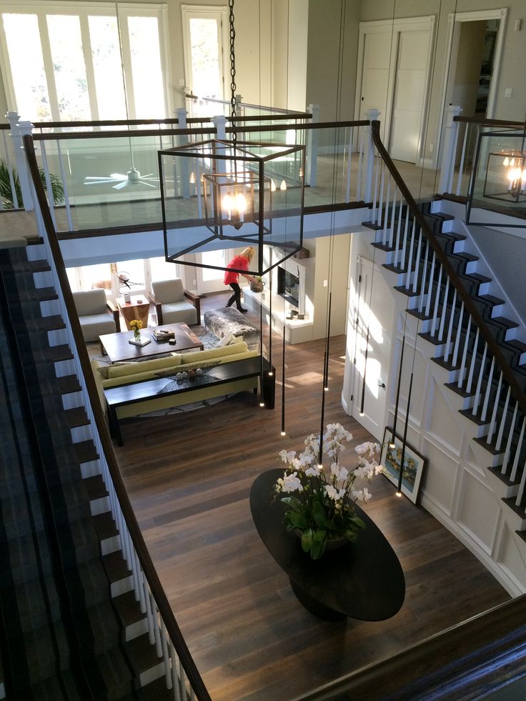 a living room filled with furniture next to a stair case on top of a hard wood floor