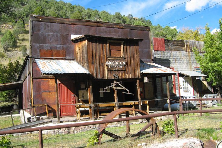 an old wooden building sitting on the side of a road