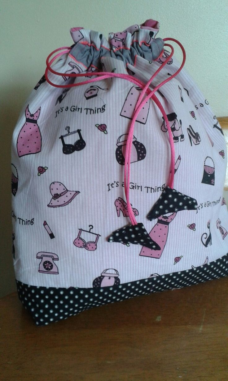 a white bag with pink and black designs on it sitting on top of a wooden table