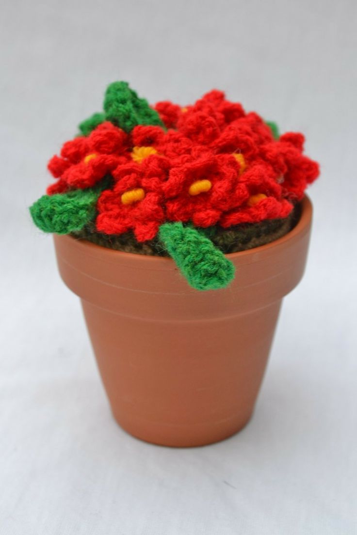 crocheted red flowers in a clay pot