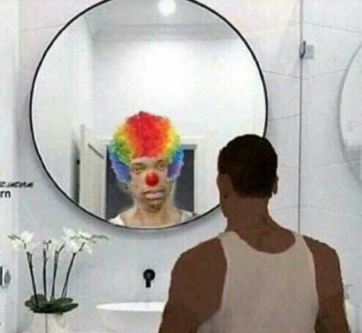 a man is looking at himself in the bathroom mirror with clown wig on his head