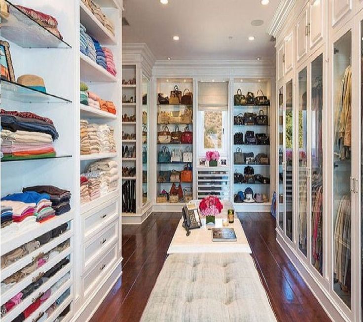 a large walk in closet with lots of shoes and handbags on the shelfs