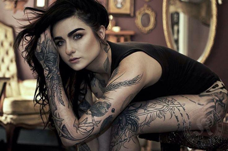 a woman with tattoos on her arms and legs