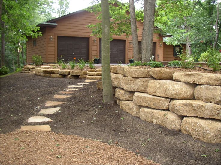 a large rock wall in front of a house