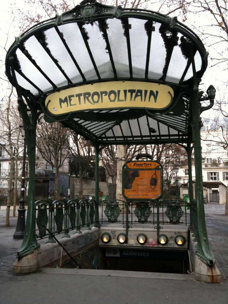 a train station with a sign that says metropolitan on the front and an overhang above it