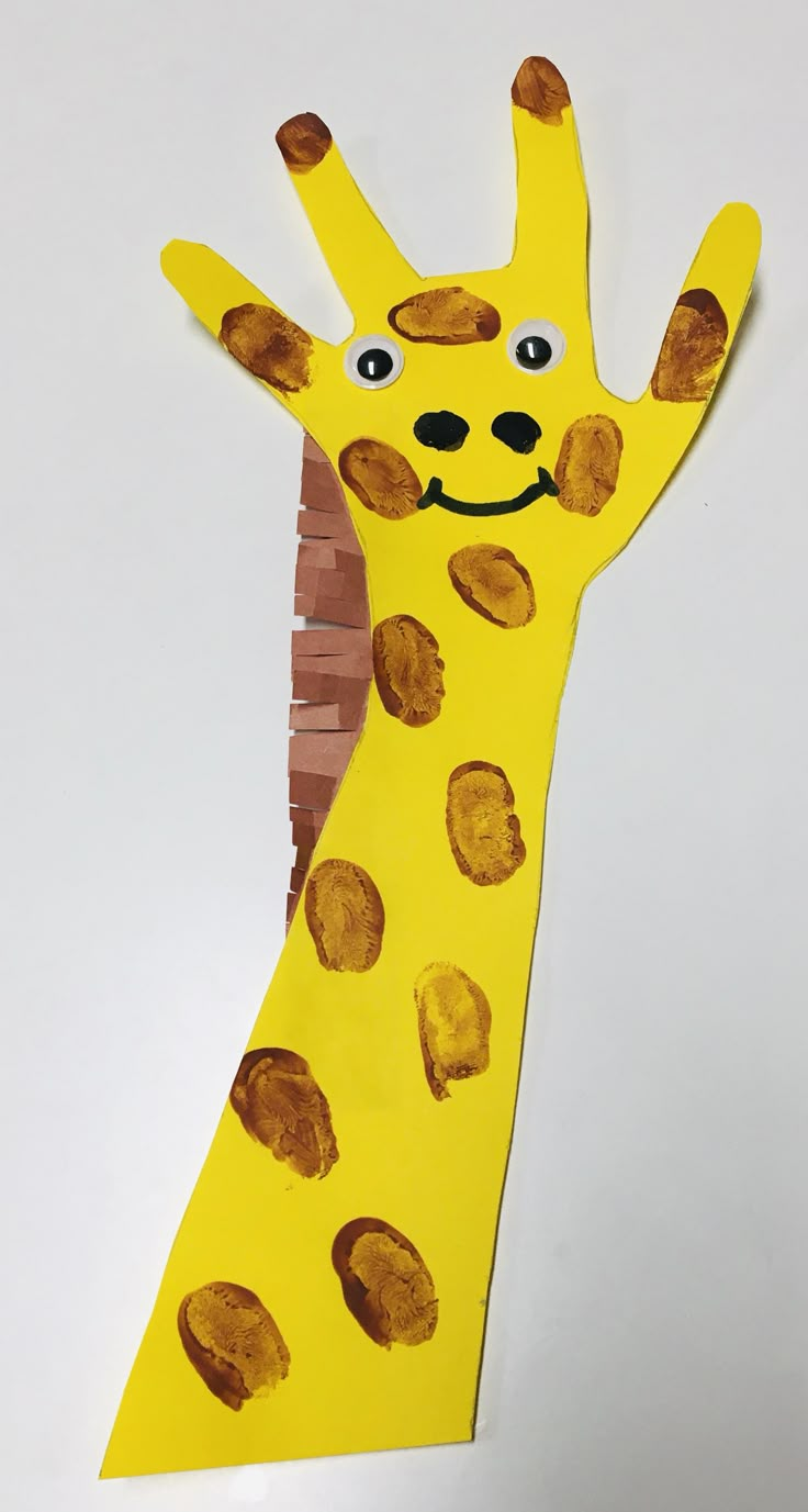 a child's hand made out of paper with a giraffe on it