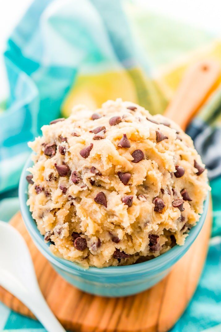 a bowl filled with cookie dough on top of a wooden cutting board