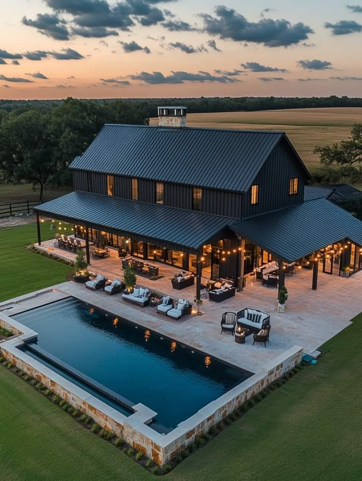 an aerial view of a large house with a swimming pool and covered patio in the foreground