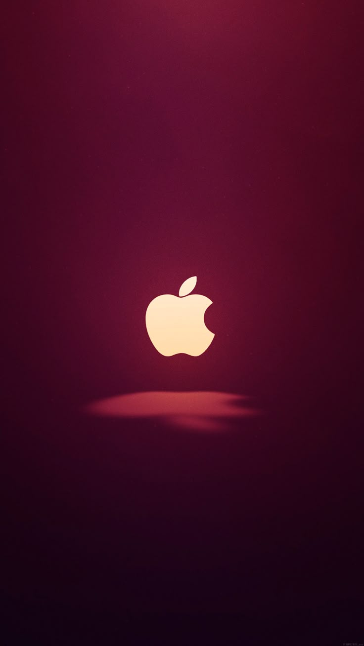 an apple logo is shown on a dark red background with the light shining through it