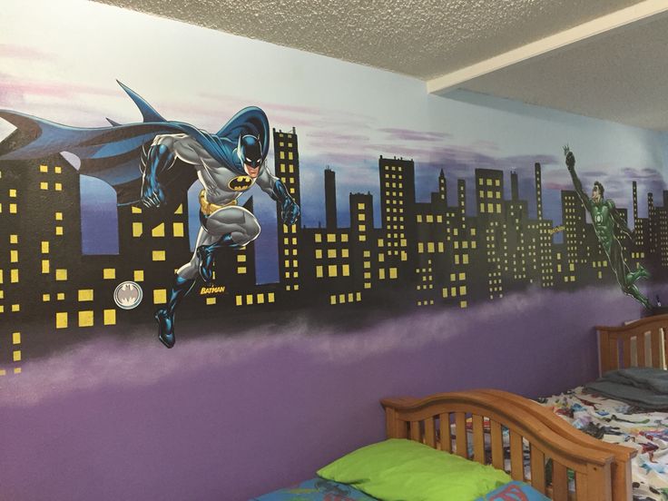 a bedroom with a batman mural on the wall