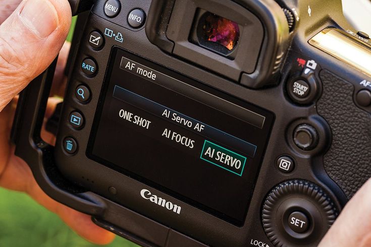 a person holding up a camera with the screen showing it's time and settings