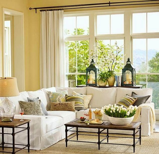 a living room with yellow walls and white furniture