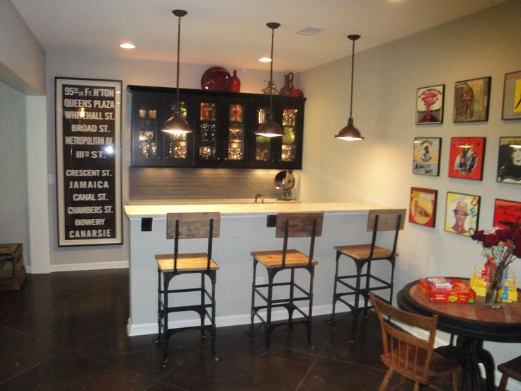 a bar with stools and pictures on the wall