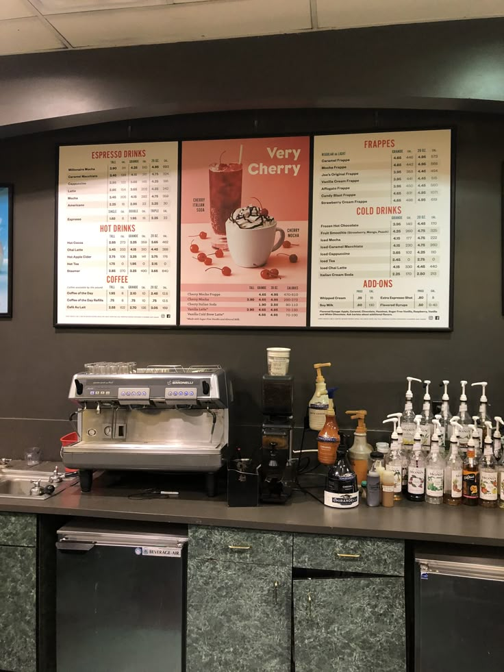 there are menus on the wall above the coffee machine and other items behind the counter