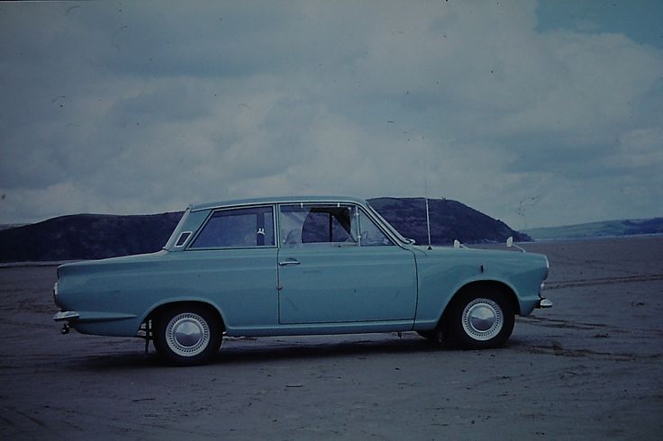 an old blue car is parked in the desert