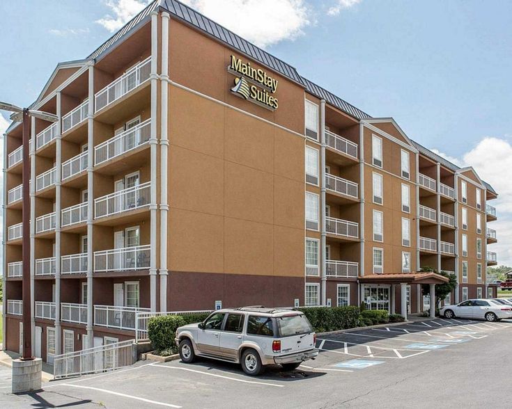 an apartment building with cars parked in the parking lot