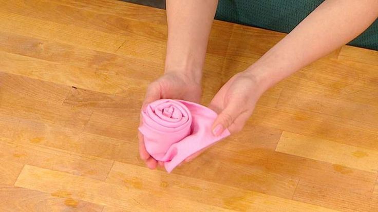 a woman is cleaning the floor with a pink cloth on it's end,