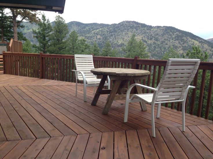 two chairs and a table on a wooden deck