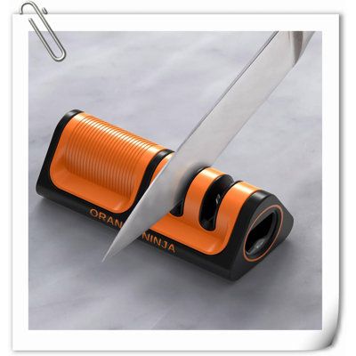 an orange and black sharpener with a large knife in it's blade holder