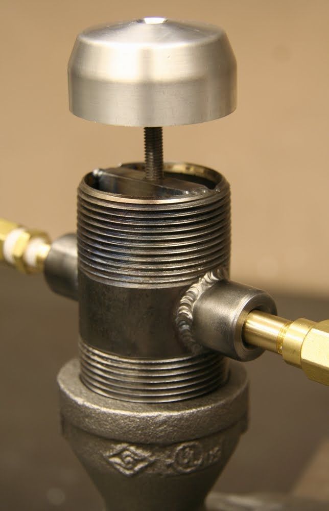 a close up of a metal object with a yellow hose attached to the top of it