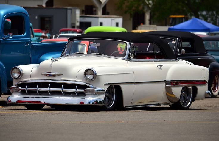 an old car is parked in a parking lot